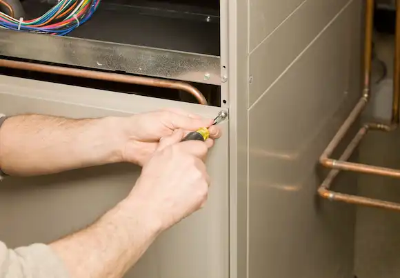 HVAC technician repairing a furnace after a furnace stopped working in the Portland cold weather.