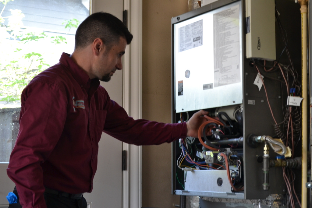 HVAC technician repairing a furnace in Southwest Portland.