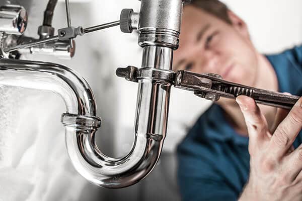 Plumber repairing a pipe wit low water pressure in Portland