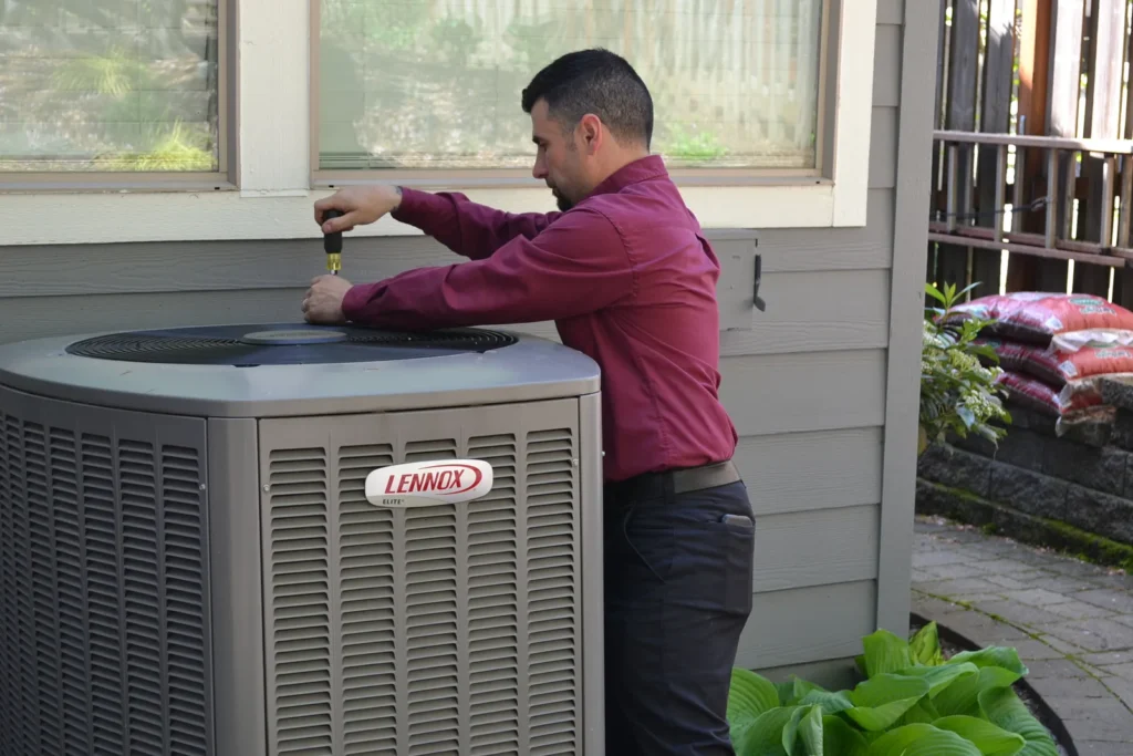 Technician repairing an AC in Portland home.