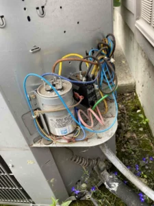 Technician replacing an overloaded AC fan motor before peak cooling season in Clackamas OR.